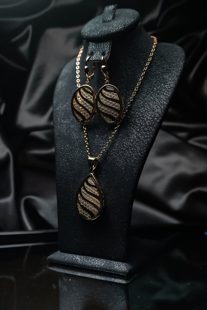 A sophisticated jewelry set featuring a necklace and earrings on a retail display.