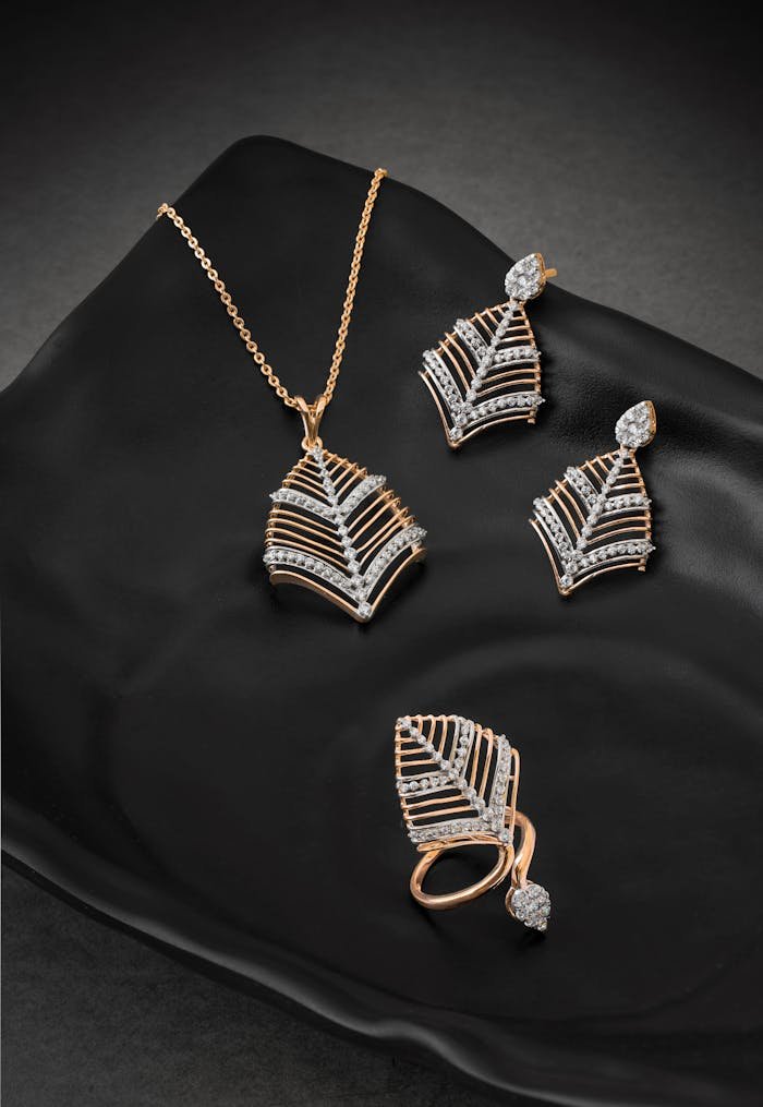 Elegant diamond necklace, earrings, and ring set displayed on a stylish black plate.